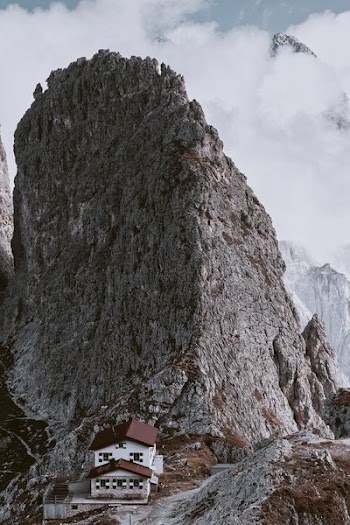 white 2-story house beside mountain cliff during daytime