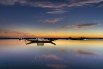 White and Black Boat on Body of Water Under Blue and Gray Skies