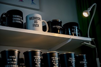 White and Black Ceramic Mugs on White Wooden Shelf