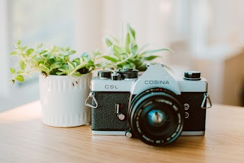 White and Black Cosina Camera on Table
