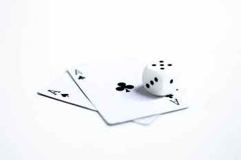 White and Black Dice on Two Ace of Clubs and Spades Cards