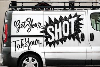white and black van with Get Your Shot text