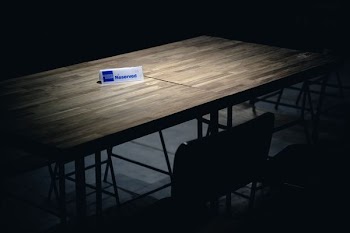white and blue reserved signage on brown table