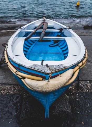 White and Blue Wooden Boat on Seashore