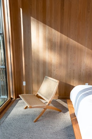 White and Brown Armchair Beside Brown Wooden Wall · Free Stock Photo