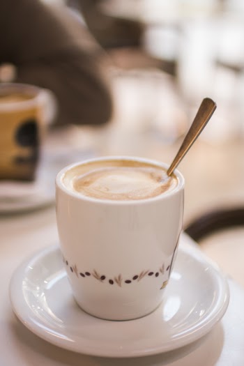White and Brown Ceramic Cup Filled With Latte on White Ceramic Saucer