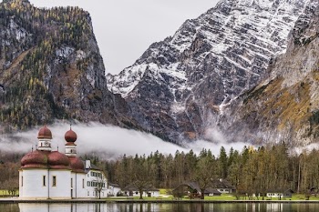 White and Brown Mosque Beside Body of Water Near Rocky Mountain