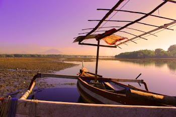 White and Brown Rowboat on Calm Body of Water during Sunset