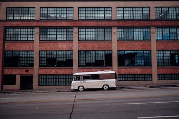 white and brown van in front of brown concrete building
