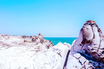 white and gray stone formation near sea at daytime