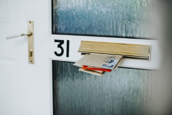 White And Green Door Filled With Envelopes