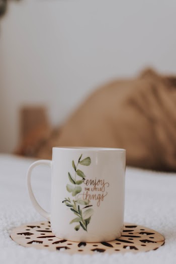White and Green Leaf Graphic Mug on Brown Cutout Base