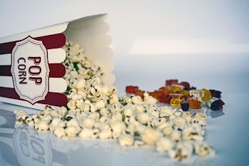 White and Green Pop Corns Beside Red Gummy Bear