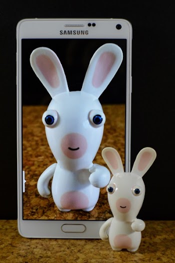 White and Pink Toy on Screen of White Samsung Smartphone