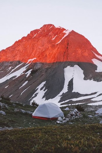 white and red camping tent near mountain