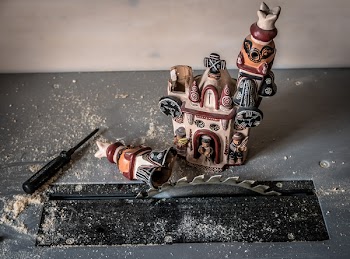 White and Red Chapel Carved Miniature Near Wood Dust and Driver on Table Saw