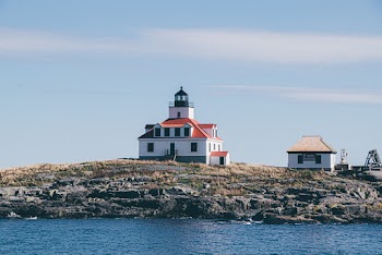 White and Red Concrete House Beside Sea
