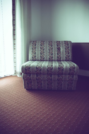 White and Red Floral Fabric Sofa Near Corner Wall
