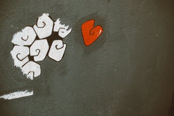 White and Red Graffiti on Black Concrete Surface