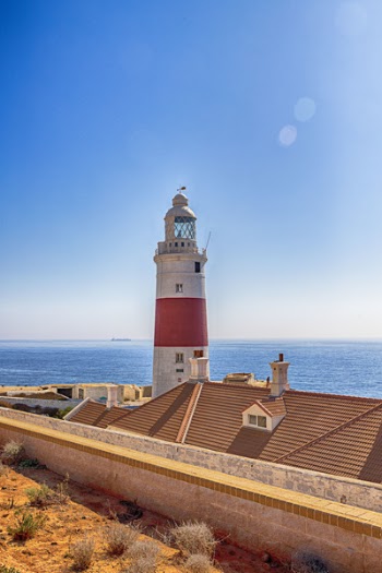 White and Red Lighthouse Beside Sea Landscape Photography