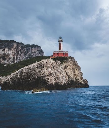white and red lighthouse near sea shore