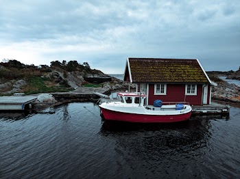 White and Red Powerboat Park Beside Red House