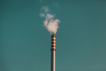 white and red striped tower emitting smoke
