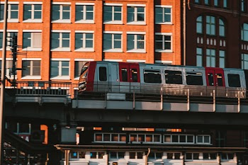 White and Red Train Near Brown Concrete Building