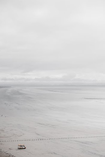 white and yellow RV on seashore under white sky during daytime