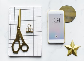 White Android Smartphone Beside Scissors on White Textile