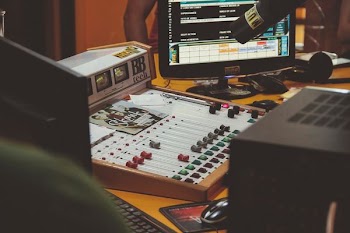 white audio mixer beside black flat screen computer monitor
