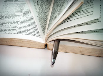 White Ballpoint Pen on Book Pages