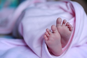 White Bed Spread Near a Human Foot during Night Time