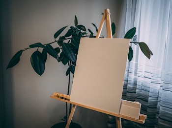 White Board on Easel Beside Green Plant