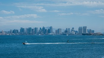 White Boat on Body of Water Near Buildings
