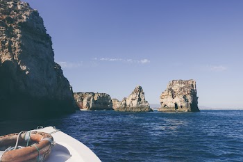 White Boat on Near Cliffs and Rock Formations