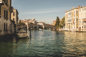 White Boat on River Near White and Brown Building