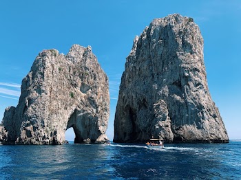 White Boat Passing Stone Formations on Ocean