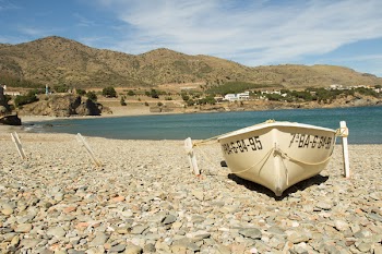 White Boat Placed in the White Stone Area Near Body of Water