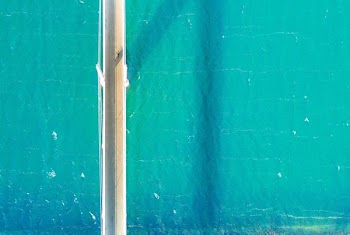 white bridge near teal body of water