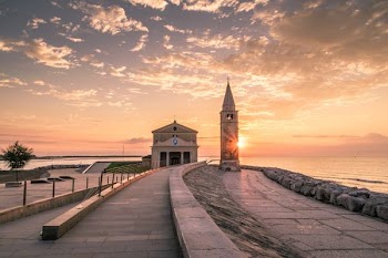 white building beside tower during sunset