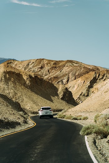 White Car on Road Between Rocks