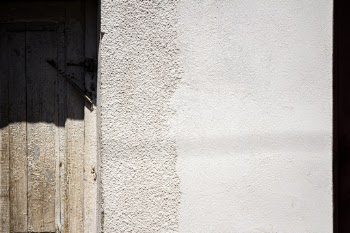 White cement wall with wooden door
