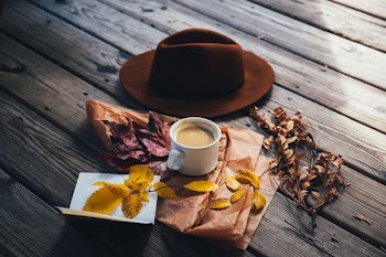 white ceramic coffee mug beside cowboy hat