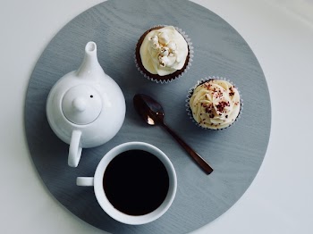 White Ceramic Cup and Teapot with Cupcakes