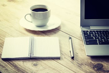 White Ceramic Cup on White Round Saucer Near Spiral Notebook