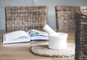 White Ceramic Mortar and Pestle Beside Book