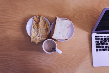 White Ceramic Mug Beside Bread on White Ceramic Saucer