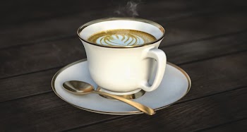 White Ceramic Mug Beside Gold Spoon