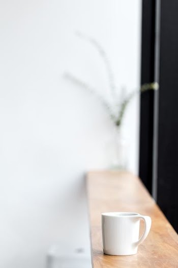 white ceramic mug on brown wooden board